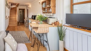 A spacious loft with a dining area, kitchen, and a TV. - 1 Bed in Mosedale (oc-b37510) (Mosedale)