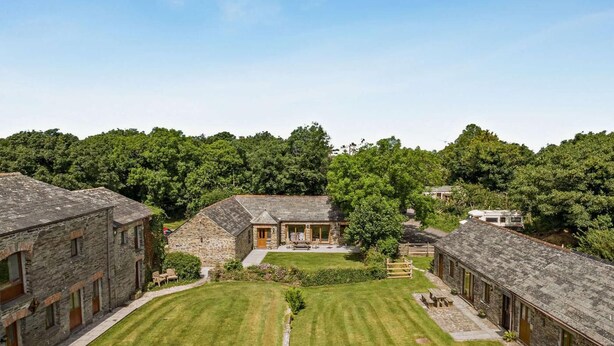 A stone building with a central courtyard, surrounded by trees. - 2 Bed in St. Ervan (oc-s36909) (Saint Ervan)
