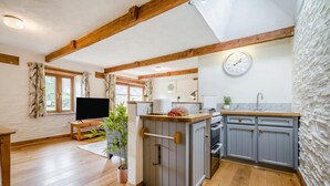 A modern kitchen with grey cabinets, a built-in oven, and a clock on the wall. - 2 Bed in St. Ervan (oc-s36909) (Saint Ervan)