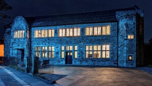 Un bâtiment en pierre doté de nombreuses fenêtres et d’une entrée centrale.