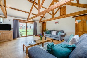 A spacious living room with a wooden ceiling, a grey sofa set, a coffee table, and a television on a wooden cabinet. - 2 Bed in St. Ervan (oc-o36911) (Saint Ervan)