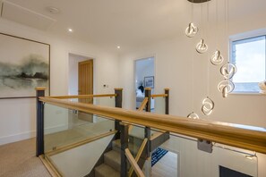 A modern interior with a glass railing staircase, a minimalist design, and pendant lighting. - 4 Bed in Padstow (oc-p36067) (Constantine Bay)