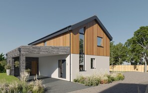 Ein modernes, zweistöckiges Haus mit Naturstein-Fassade, Holzaußenbereich und einem gepflasterten Auffahrt.