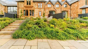 A stone house with a garden and steps leading to the entrance. - 2 Bed in Brampton (oc-88663) (Brampton)