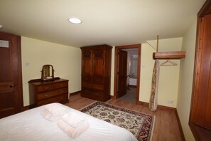 A bedroom with a bed, a dresser, a wardrobe, and a bathroom visible through an open door. - 10 Bed in Alness (oc-ca233) (Alness)