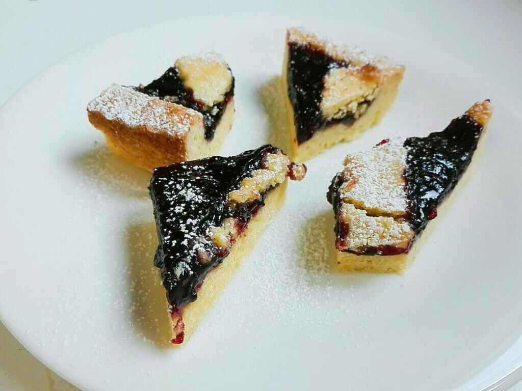 Cuatro pasteles triangulares sobre un plato blanco.