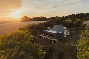 A modern house with a deck, surrounded by trees and a field. - 4 Bed in Hartland (oc-s37525) (Hartland)