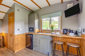 A compact kitchen with a microwave, sink, and wooden bar stools. - 1 Bed in Smardale (oc-e37511) (Smardale)