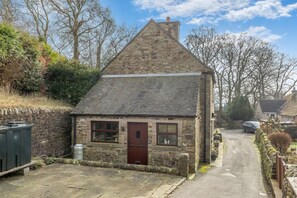 A stone cottage with a sloped roof, a front door, and windows. - 3 Bed in Longnor (oc-r34925) (Longnor)
