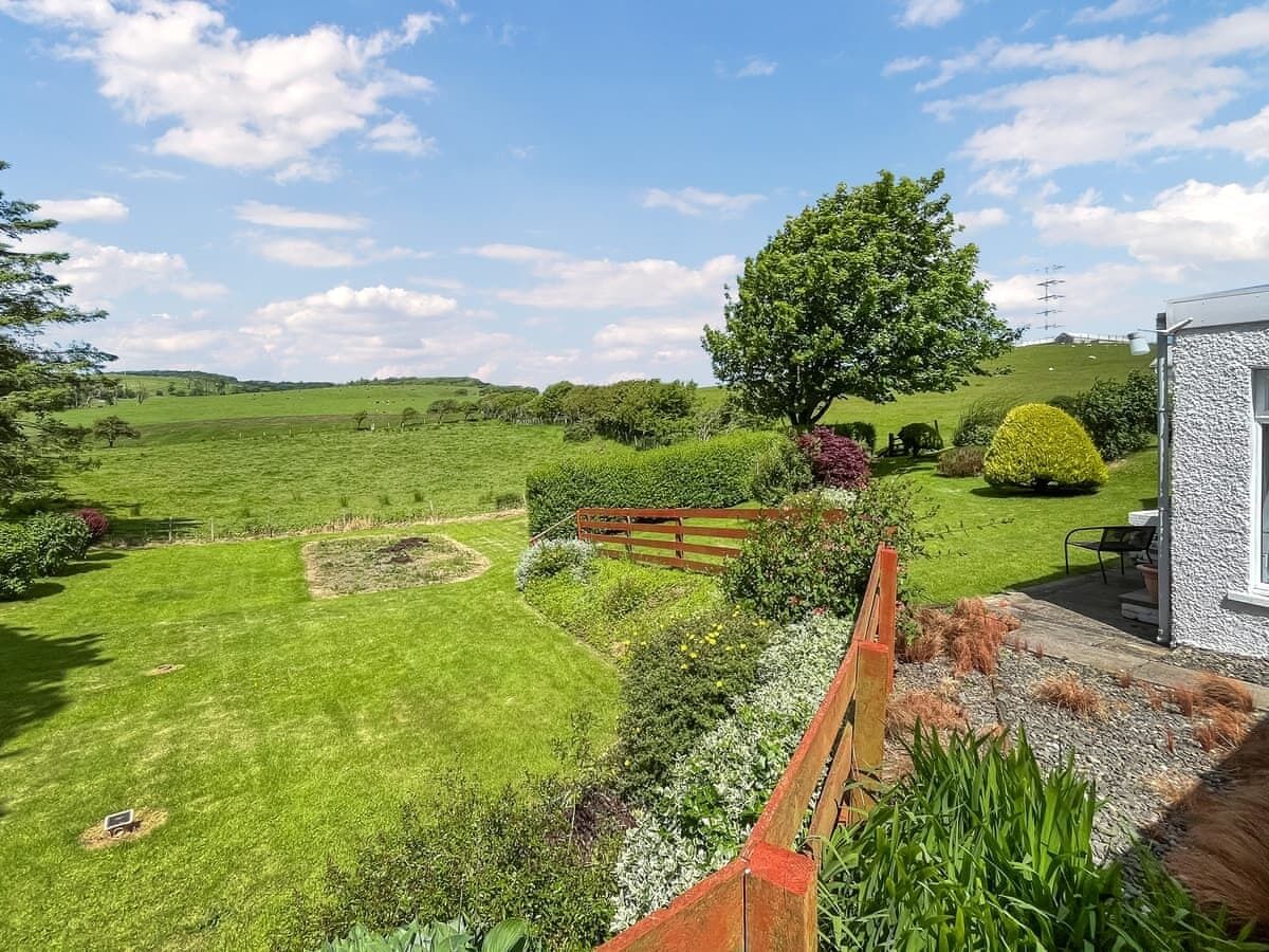A well-maintained garden with a variety of plants and a wooden fence.