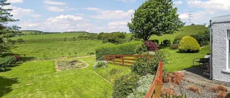 A well-maintained garden with a variety of plants and a wooden fence.