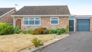 A single-story brick house with a tiled roof, a front door, and a garage. - 2 Bed in Cromer (oc-c36333) (Cromer)