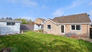 A residential property with a well-maintained lawn, a brick house, and a detached garage. - 2 Bed in Cromer (oc-c36333) (Cromer)