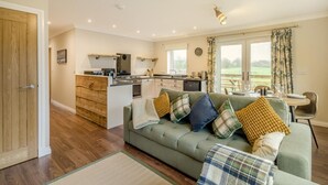 A cozy living room with a sofa, a dining table, and a kitchen area. - 2 Bed in Ochiltree (oc-w37517) (Ochiltree)
