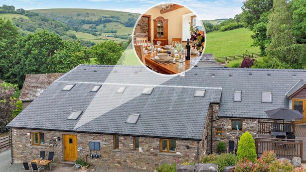 A stone house with a large dining area, a patio, and a view of rolling hills. - 2 Bed in Brecon (oc-44182) (Llanfihangel Nant Bran)