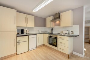 A modern kitchen with light-colored cabinets, a built-in oven, a microwave, and a coffee maker. - 1 Bed in Hastingleigh (oc-b36344) (Hastingleigh)