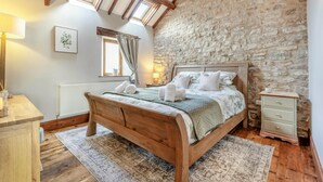 A bedroom with a stone wall, a wooden bed, a nightstand, and a window with curtains. - 2 Bed in Great Edstone (oc-t36332) (Great Edstone)