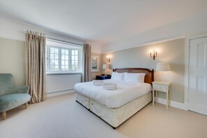 A hotel room with a bed, bedside tables, a chair, and a window with curtains. - 5 Bed in Holme Next The Sea (oc-2265) (Holme-next-the-Sea)
