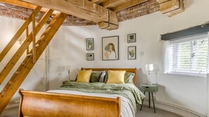 A bedroom with a wooden bed, a sloped ceiling, a window with blinds, and framed artwork on the wall. - 2 Bed in Wrangle (oc-t37494) (Old Leake)