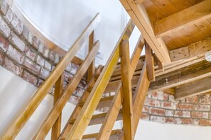 Eine Holztreppe vor einer Backsteinwand.