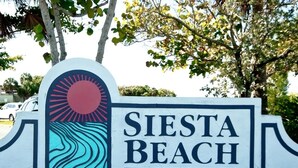 Siesta Beach -nimikyltti, jossa on tyylitelty aurinko- ja aaltokuvio sekä Sarasota Countyn puisto- ja virkistysosaston nimi.