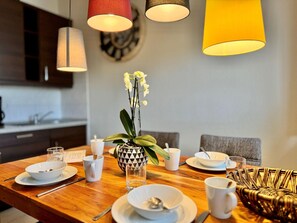 Una mesa de comedor con platos, tazas y un florero.