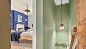 A room with a bed, a fireplace, and two hanging lamps. - 2 Bed in Gunnerside (oc-g37866) (Gunnerside)