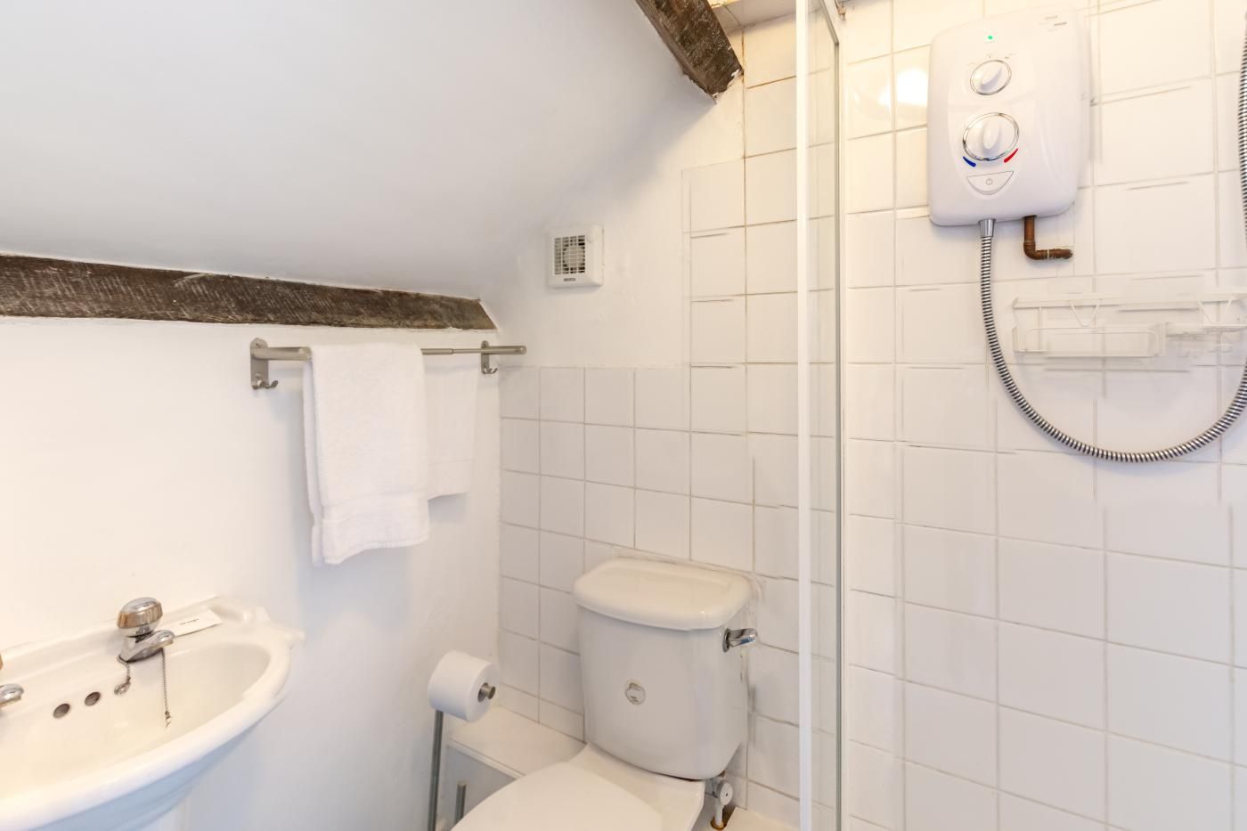 Un baño con lavamanos, inodoro y ducha.