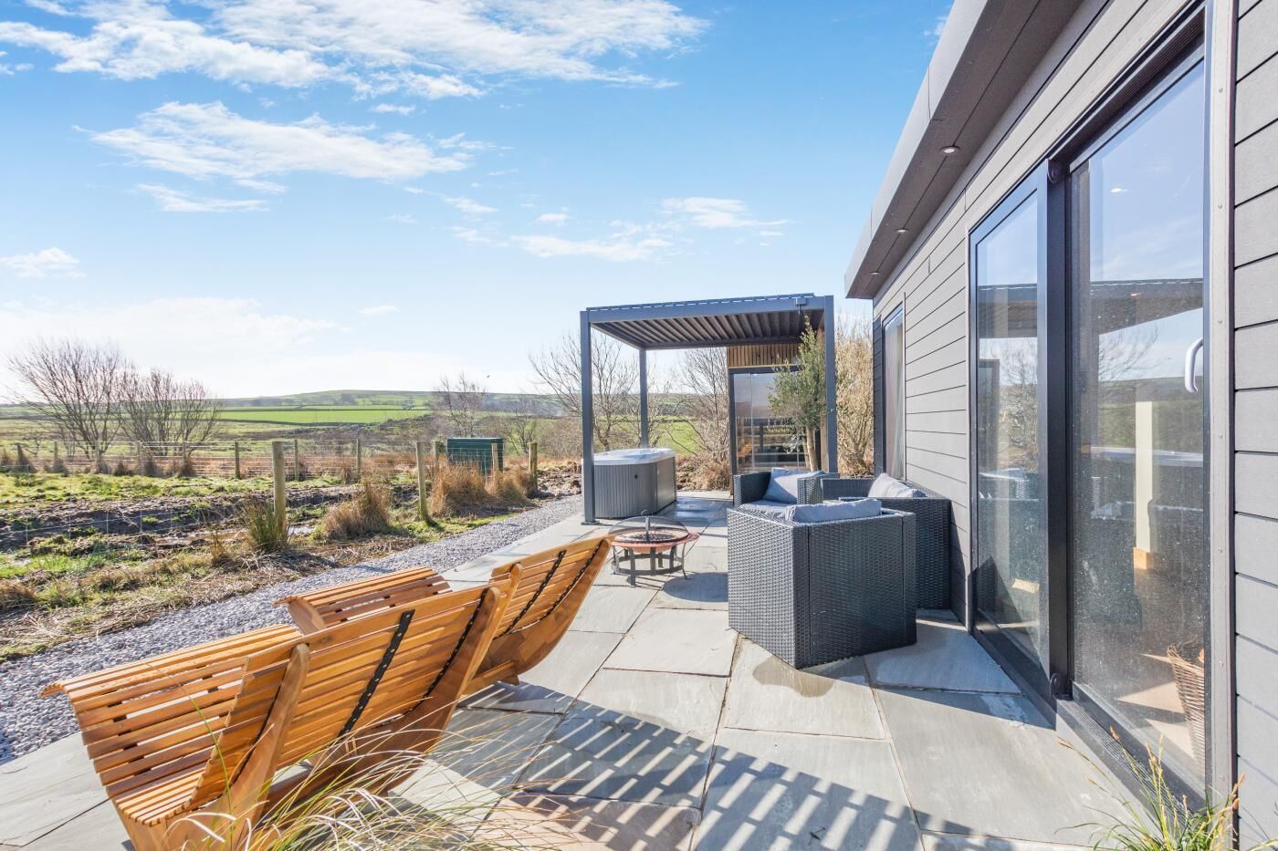 A patio with outdoor furniture, a pergola, and a view of the countryside.