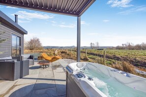 A modern outdoor patio with a hot tub, wicker furniture, and a view of the countryside. - 1 Bed in Austwick (oc-b37509) (Austwick)