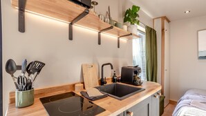 A modern kitchen with a built-in stove, a sink, and a coffee maker. - 1 Bed in Austwick (oc-b37509) (Austwick)