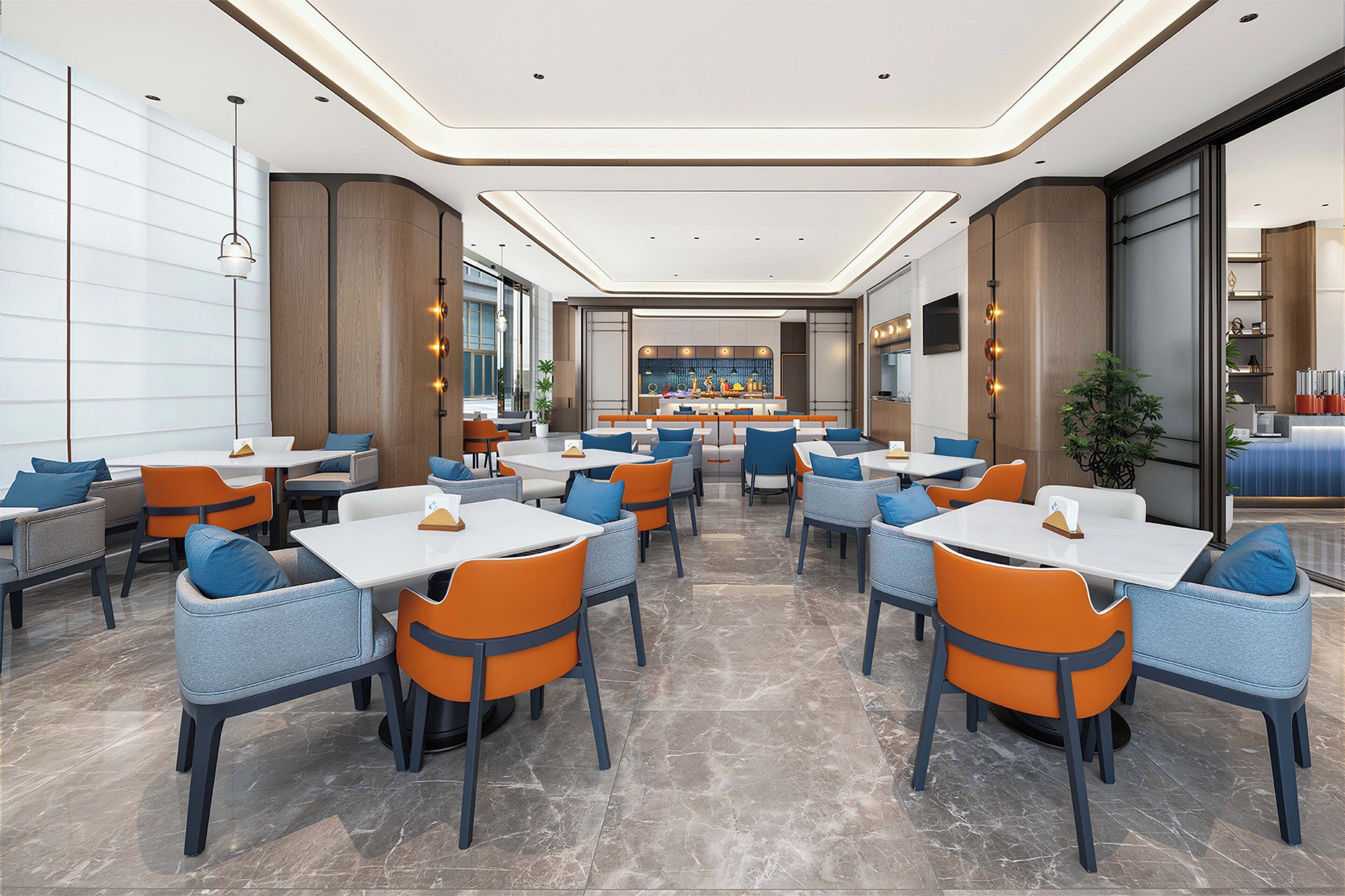 A modern restaurant with multiple tables and chairs, a bar area, and a large window providing a view.