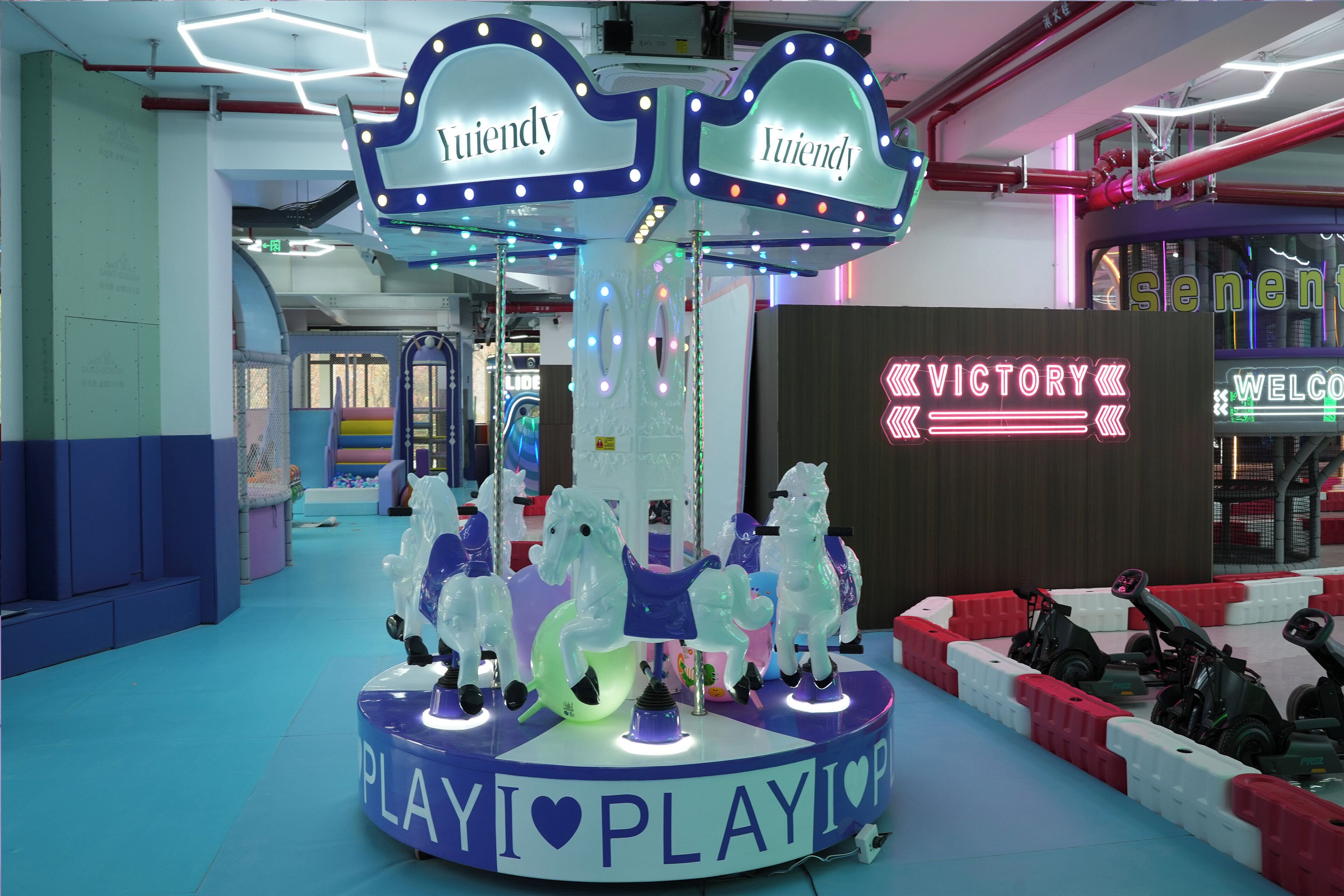 Un carrusel con caballos y un letrero que dice 'Play I ♥ Play I ♥'.