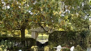 A garden with a table and chairs, a pergola, and a stone wall. - 1 Bed in Castleton (oc-s36309) (Castleton)