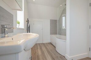Ein modernes Badezimmer mit einem großen Waschbecken, einer Dusche und einer Toilette.