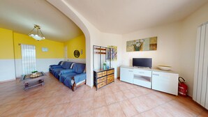 A living room with a sofa, TV, white cabinets, and a fireplace. - Spiaggia Apartment by Booking Lake Garda (Manerba del Garda)