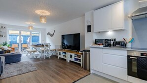A modern kitchen with white cabinets, a built-in oven, and a black toaster. - 4 Bed in Broadstairs (oc-81104) (Broadstairs)