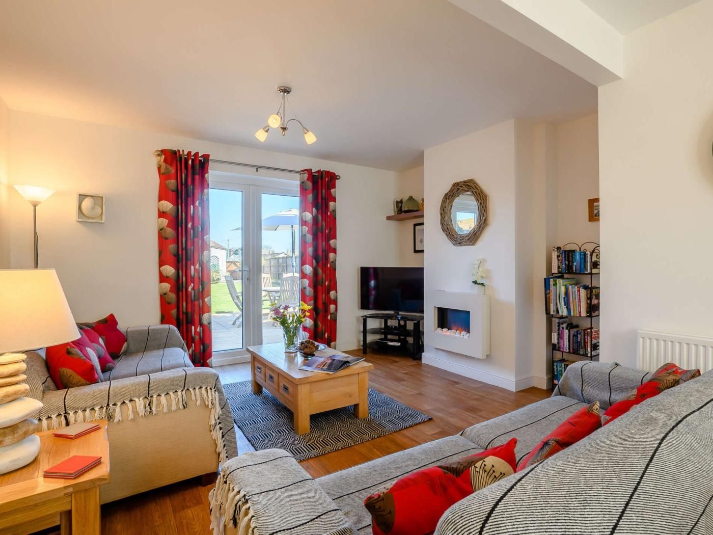 A living room with a sofa, coffee table, TV, fireplace, and a bookshelf.