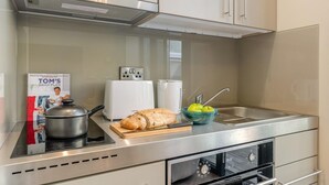 Eine Küche mit einem Herd, einem Toaster und einer Schüssel Äpfel.
