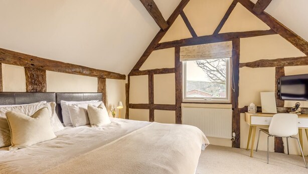 Une chambre avec un grand lit, un bureau et une fenêtre.