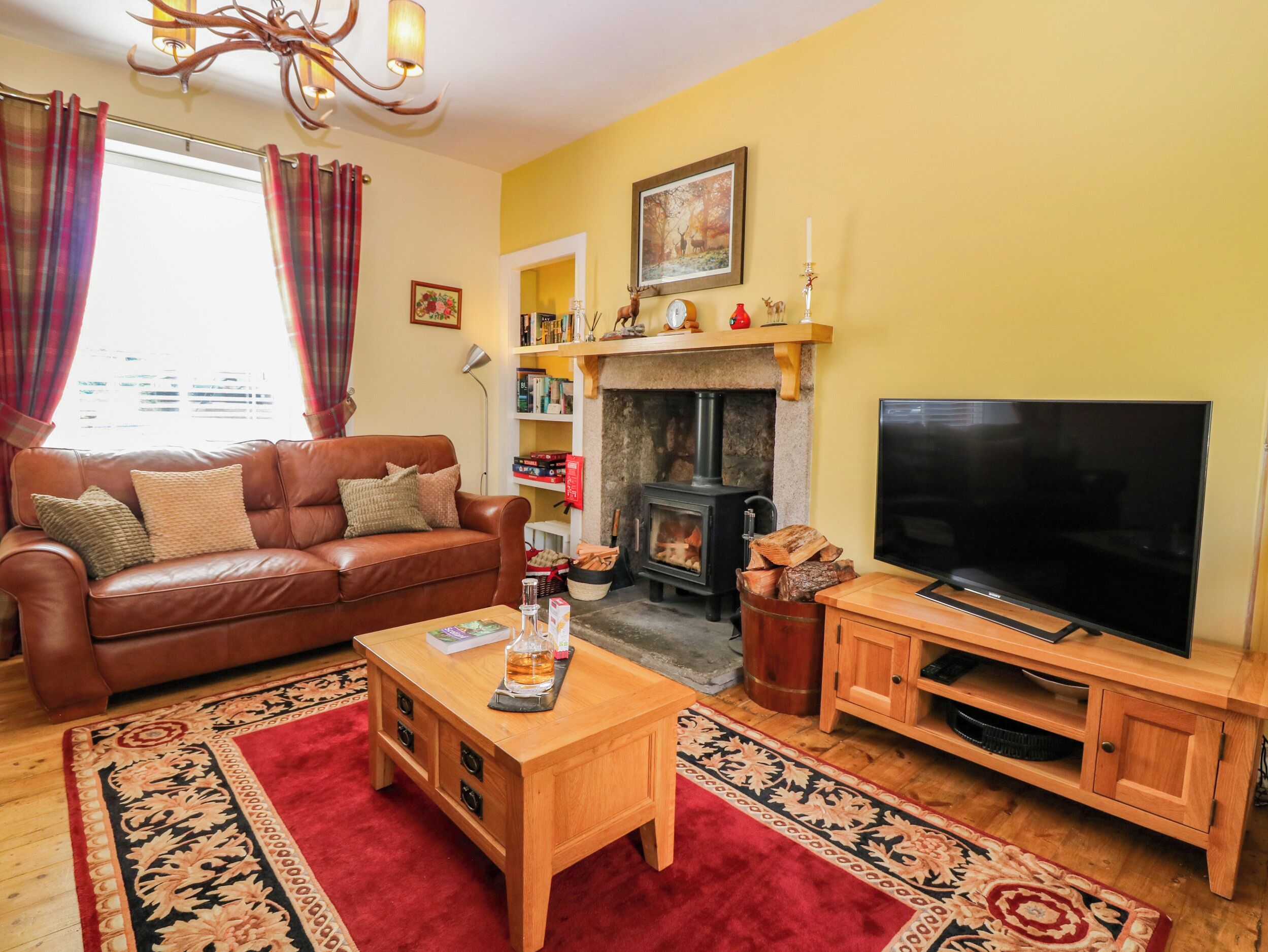 A cozy living room with a fireplace, a sofa, a coffee table, and a television.