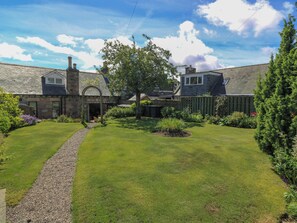A stone house with a garden, a gravel path, and a wooden fence. - St Kilda (Ballater)