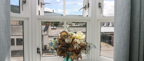 A window with a vase of flowers on a windowsill.