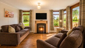 A living room with a fireplace, a television, and a view of the outdoors. - 2 Bed in Athelington (oc-a35072) (Athelington)
