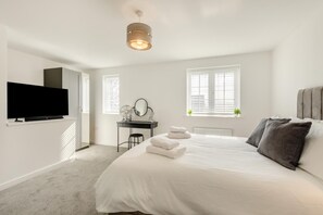 A modern bedroom with a bed, a desk, a TV, and a window. - 3 Bed in Aspatria (oc-h38206) (Aspatria)