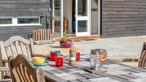 A wooden table with a bottle, glasses, and a metal container. - 3 Bed in Eastbury (oc-t38204) (Eastbury)