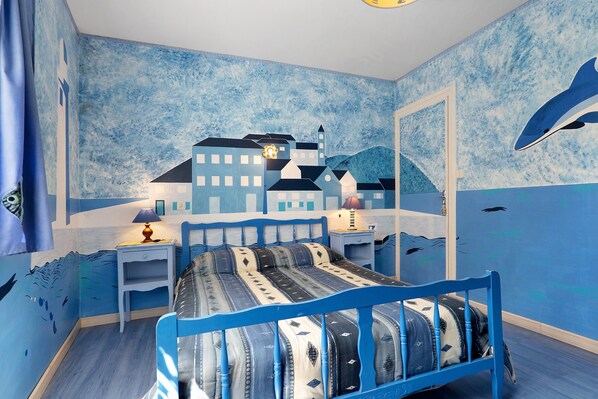 A bedroom with a bed, nightstands, and a wall mural.