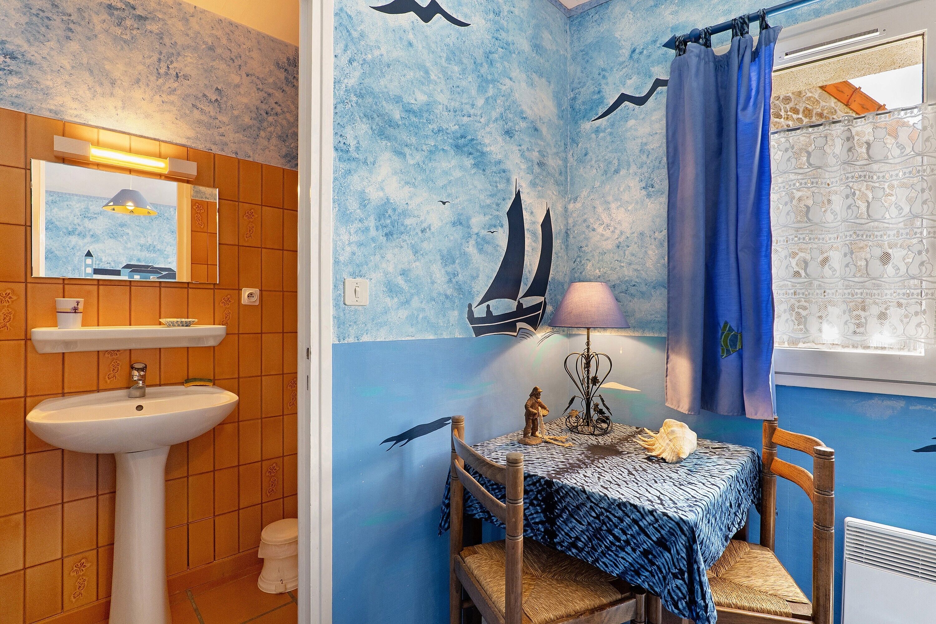 Une salle de bain avec un lavabo, un miroir et des murs carrelés.