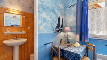 Une salle de bain avec un lavabo, un miroir et des murs carrelés.
