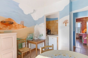 A dining area with a table, chairs, and a wall mural.